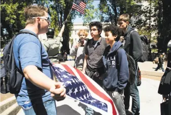  ?? Photos by Noah Berger / Special to The Chronicle ?? Kristofer Hanson of Sacramento (left) speaks with Berkeley High School students on lunch break who came to Martin Luther King Jr. Civic Center Park, where protesters gathered.