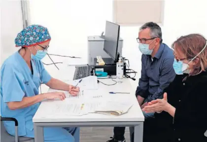  ??  ?? Una médica atiende a dos pacientes.