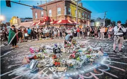  ?? JOHN MINCHILLO THE ASSOCIATED PRESS FILE PHOTO ?? Protesters gather at a memorial for Floyd where he died outside Cup Foods on East 38th Street and Chicago Avenue, in Minneapoli­s.