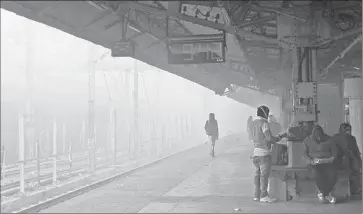  ?? Rajesh Kumar Singh
Associated Press ?? PEOPLE WAIT at a station in Allahabad. Among the fog fixes India has tried over the years are yellow paint, louder whistles, GPS systems and “detonators,” which simulate an explosion when trains approach signals.