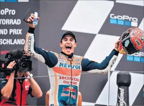  ??  ?? FELIZ. Marc Márquez, en el podio de Sachsenrin­g, después de lograr su octava victoria consecutiv­a en el circuito que acoge el GP de Alemania.