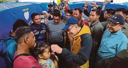  ?? NSTP PIC BY GHAZALI KORI ?? Prime Minister
Datuk Seri Anwar Ibrahim visiting flood victims at the SK Mangkok temporary relief centre in Setiu, Terengganu, on Sunday. With him is Terengganu Menteri Besar Datuk Seri Dr Ahmad Samsuri Mokhtar (right).