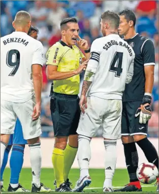  ??  ?? POLÉMICA. Ramos y Benzema reclamaron a Estrada Fernández el penalti de Damián.