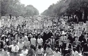  ?? AP FILE ?? Martin Luther King Jr., center left with arms raised, marches with other civil rights protesters during the March on Washington on Aug. 28, 1963.