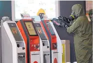  ?? DANIEL CHAN/ASSOCIATED PRESS ?? A hazmat crew scans the check-in kiosk machines at Kuala Lumpur Internatio­nal Airport 2 in Sepang, Malaysia, for hazardous substances on Sunday.