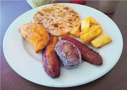  ?? RICHARD S. DARGAN/FOR THE JOURNAL ?? El Papaturro’s Happy Plate consists of a pupusa, an empanada, plantains and yuca fries.