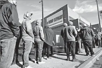  ?? ANTONIO PEREZ/CHICAGO TRIBUNE ?? On the second day of legal recreation­al cannabis sales, people wait at the Midway Dispensary store in Chicago.