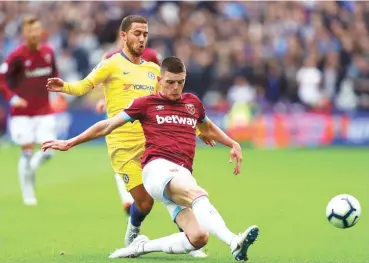  ??  ?? Eden Hazard (left) of Chelsea game at the London Stadium tackles Declan Rice (right) of West Ham during yesterday's