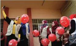  ?? —AFP ?? MOSUL: Members from the ‘Rebirth Generation’, an Internet born group of Iraqi youths who are trying to revive the embattled city of Mosul, pose for a photo as they organize an event to mark Valentine’s Day at a school in the eastern part of Mosul on...