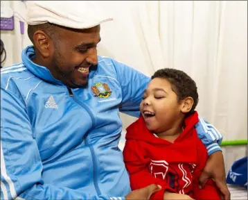  ??  ?? Hamad holding Assel in their livingroom in Irishtown, New Ross.