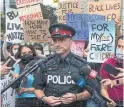  ?? RICK MADONIK TORONTO STAR ?? A police officer speaks with media during a recent protest in downtown Toronto. Calls for a different model of policing need not provoke fears of being left defenceles­s against violent criminals.