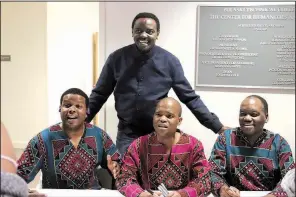  ??  ?? Benito Lubazibwa (standing) poses for a photo with members of Ladysmith Black Mambazo after their performanc­e.