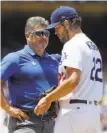  ?? Alex Gallardo / Associated Press ?? Clayton Kershaw talks with trainer Nathan Lucero in the second inning. Kershaw left the game shortly afterward.