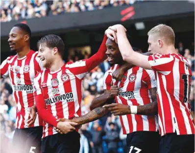  ?? (Reuters) ?? Brentford’s Ivan Toney (second from right) celebrates scoring their second goal against Brentford with teammates during their Premier League match in Manchester yesterday.