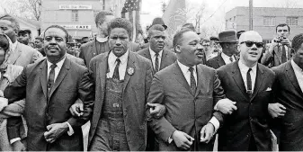  ??  ?? Dr. Martin Luther King, Jr. locks arms with his aides as he leads a march to the court house in Montgomery, Ala., on March 17, 1965. From left are. the Rev. Ralph Abernathy, James Foreman, King, Jesse Douglas, Sr., and John Lewis (partially out of...