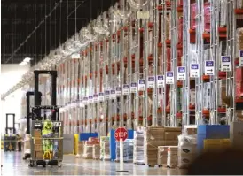  ?? DAVID ZALUBOWSKI/AP ?? An associate guides a vehicle past rows of goods during a tour of the Amazon fulfillmen­t center in Aurora, Colorado. Amazon announced last week it would raise its hourly minimum wage to $15.