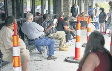  ?? (AP PHOTO/NATI HARNIK) ?? Job seekers exercise social distancing as they wait to be called into the Heartland Workforce Solutions office in Omaha, Neb., on Wednesday,. Nebraska reinstated job search requiremen­ts this week for most people claiming jobless benefits. Those unemployme­nt insurance requiremen­ts were suspended in mid-March to help employees who had lost their jobs due to the coronaviru­s.