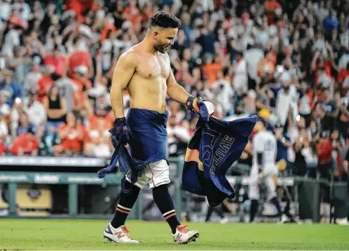  ?? Photos by Yi-Chin Lee / Staff photograph­er ?? Jose Altuve’s teammates ripped his jersey after the second baseman belted the game-winning three-run homer in the bottom of the ninth inning Sunday.