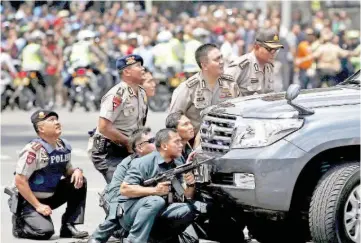  ?? — Reuters photo ?? Police officers react near the site of an attack in Jakarta on Jan 14 this year.