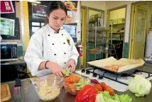  ??  ?? Katie Rowe 16, assembles the bacon, lettuce and tomato of the BLT toastie.