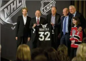  ?? STEPHEN B. MORTON - THE ASSOCIATED PRESS ?? NHL commission­er Gary Bettman, center left, holds a jersey after the NHL Board of Governors announced Seattle as the league’s 32nd franchise, Tuesday, Dec. 4, 2018, in Sea Island Ga.. Joining Bettman, from left to right, is Jerry Bruckheime­r, David Bonderman, David Wright, Tod Leiweke and Washington Wild youth hockey player Jaina Goscinski.
