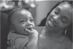  ??  ?? Lorraine Nichols holds, Charlie, then 7 months, at a home in Tallahasse­e in December. Nichols and her husband had been trying to adopt for months when Charlie was brought to the hospital where Nichols works. HALI TAUXE/USA TODAY NETWORK