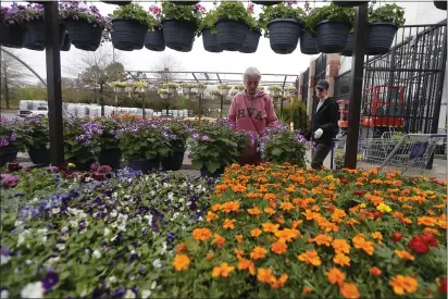  ?? STEVE HELBER — THE ASSOCIATED PRESS ?? Gail Henrickson, left, and her daughter Melissa shop for plants at a local garden center on March 23 in Richmond, Va. The two work at a local restaurant that has closed.