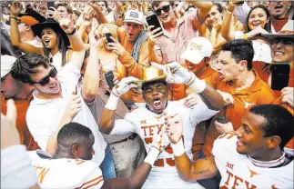  ?? Nick Wagner ?? The Associated Press Texas defensive back Josh Thompson celebrates with jubilant fans while wearing the ceremonial Golden Hat following the 19th-ranked Longhorns’ 48-45 victory over No. 7 Oklahoma in the RedRiver Showdown on Saturday in Dallas. The win moved Texas to No. 9 in this week’s AP rankings.