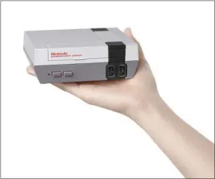  ?? The Associated Press ?? CLASSIC: This image provided by Nintendo shows the Nintendo Entertainm­ent System Classic Edition. The NES Classic Edition includes all your childhood favorites, assuming you came of age in the late 1980s or 1990s. If not, think of them as the horribly...