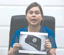  ??  ?? ‘STAY SAFE’ – Davao City Mayor Sara Duterte-Carpio shows a printed copy of the black flag of the Islamic State of Iraq and Syria (ISIS) which was brandished by members of the terrorist Maute Group, which attacked Marawi City Tuesday. (Keith Bacongco)