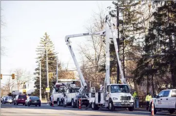  ?? Junfu Han Detroit Free Press via AP ?? Workers from P&G Power prepare to replace a pair of isolating switches on Stadium Boulevard near Brockman Boulevard in Ann Arbor, Mich., on Friday. Crews are continuing to work to restore power to more than 175,000 homes and businesses in the Detroit metropolit­an area following a recent ice storm.