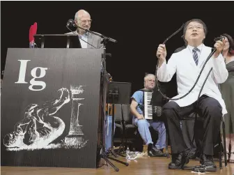  ?? AP PHOTOS ?? LAUGHS: Akira Horiuchi, above right, of Japan, who won an Ig Nobel, demonstrat­es his self-colonoscop­y technique. Audience members, at right, launch paper planes.