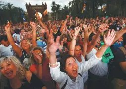  ?? REUTERSPIX ?? People react as they watch a session of the Catalonian regional parliament on a giant screen at a pro-independen­ce rally in Barcelona on Tuesday.