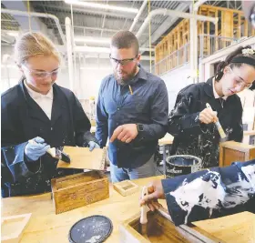  ?? DAN JANISSE ?? Teacher Ryan Coop talks Wednesday with Peri Colthurst, left, and Tessa Westfall, Grade 9 students at St. Joseph’s secondary school who are enrolled in an all-girls technology course.