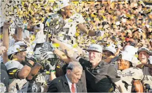  ?? STEPHEN M. DOWELL/STAFF PHOTOGRAPH­ER ?? UCF coach Scott Frost celebrates with his team after its AAC title win Saturday against Memphis at Spectrum Stadium. Frost later confirmed he is leaving UCF to coach at Nebraska, his alma mater.