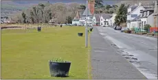  ??  ?? The decorative flower pots line the shore at Lamlash.