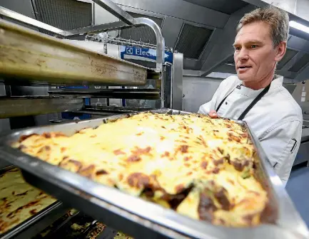  ?? PHOTOS: SCOTT HAMMOND/FAIRFAX NZ ?? BV Gourment second chef Chris Pearce prepares a vegetable bake.