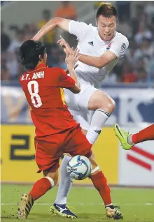  ?? Yonhap ?? Korean footballer Kim Shin-uk, behind, fights for the ball with a Vietnamese player during a game against the Southeast Asian country’s Under-23 national team at My Dinh Stadium in Hanoi on Saturday.