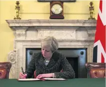  ?? Christophe­r Furlong / Reuters ?? British prime minister Theresa May signs the official letter to launch Brexit.