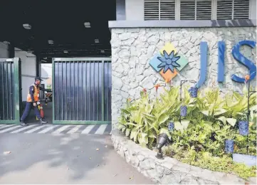  ??  ?? A security guard opens the gate outside the Jakarta Intercultu­ral School (JIS) in Jakarta.