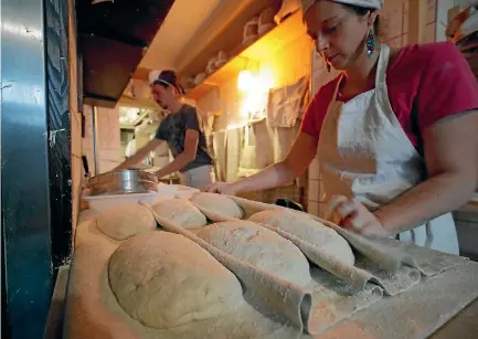  ?? PHOTO: REUTERS ?? The baker and his assistant work on bread doughs at Le Bricheton bakery in Paris. A 1919 law obliges French bakeries to close one day a week.