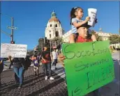  ?? Allen J. Schaben Los Angeles Times ?? PARENTS and children march in Pasadena during a 2019 protest against the school district’s decision to close some campuses because of declining enrollment.