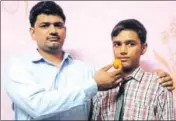  ?? MANOJ DHAKA/HT ?? Kartik’s father offers him a laddoo after his stellar performanc­e in Class 10 exams in Jind on Monday.