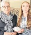  ?? ETHAN PAQUET/SALTWIRE NETWORK ?? Mae and Alecia Arsenault admire the snowball Mae kept in her freezer for 11 years, a gift from her granddaugh­ter.