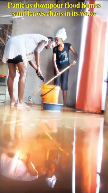  ??  ?? Amanda Ndlovu, left, and Karneta Marule, try to mop up after the heavy rains flooded their home yesterday.