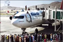  ?? WAKIL KOHSAR/ GETTY IMAGES ?? Afghan people climb atop a plane as they wait at the Kabul airport on Monday after a stunningly swift end to Afghanista­n's 20-year war, as thousands of people mobbed the airport trying to flee the Talian’s feared hardline brand of Islamist rule.