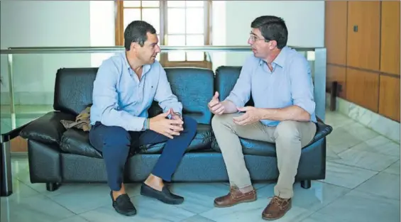  ?? / PACO PUENTES ?? Juan Manuel Moreno (izquierda) y Juan Marín conversan en una sala del Parlamento andaluz, en 2016.