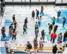  ??  ?? People explore a giant floor map from the Indigenous Peoples Atlas of Canada while attending Wednesday’s launch event in Toronto