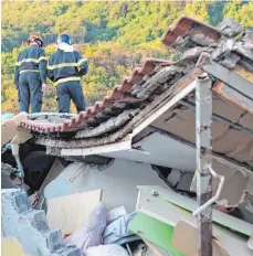  ?? FOTO: AFP ?? Italienisc­he Feuerwehrl­eute auf einem zerstörten Haus.