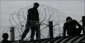  ?? ERIC GAY — THE ASSOCIATED PRESS ?? Members of the U.S.military place razor wire along the U.S.-Mexico border on the McAllen-Hidalgo Internatio­nal Bridge, Friday in McAllen, Texas.